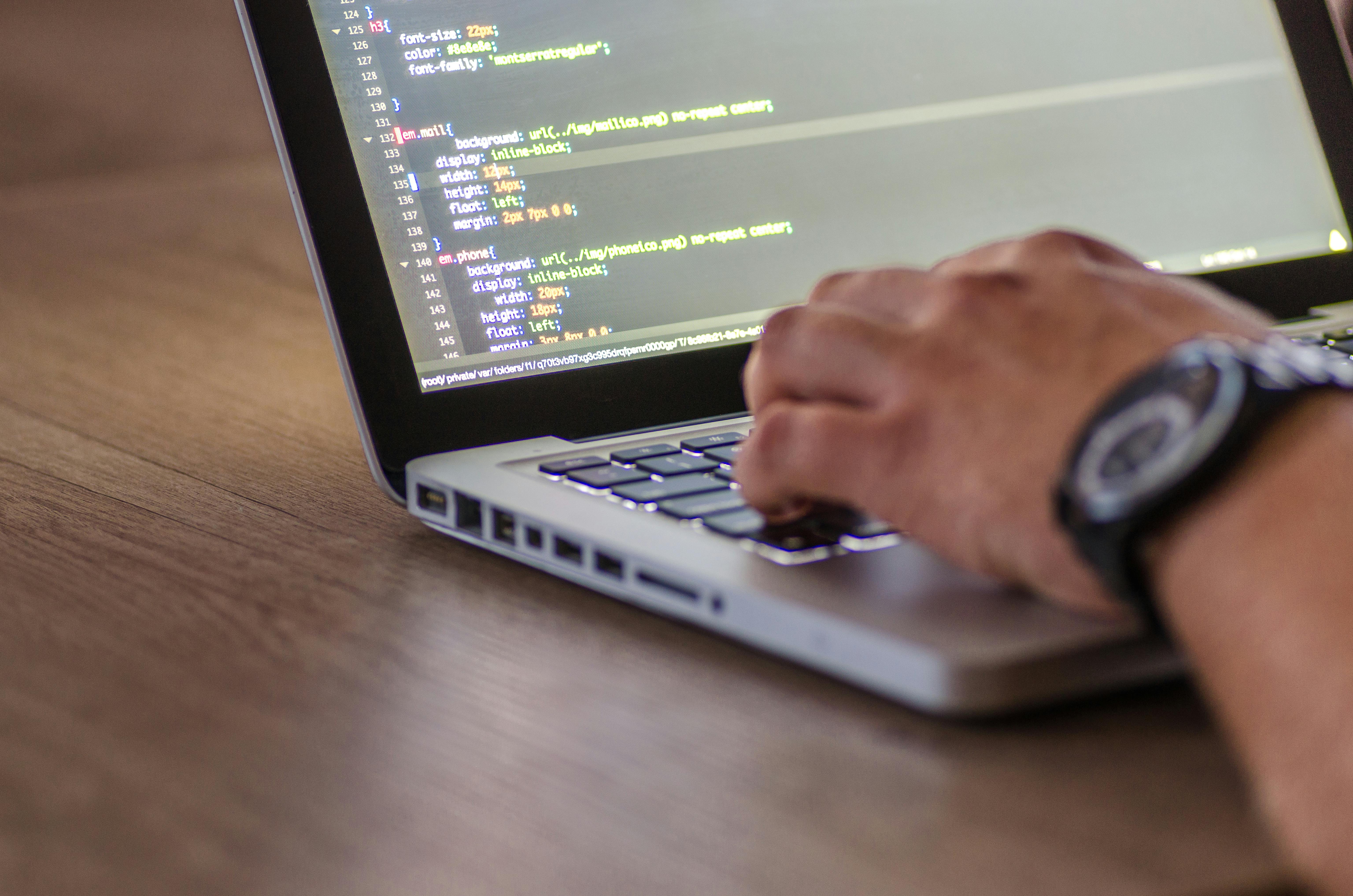 Person typing code on a laptop